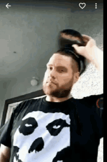 a man with a beard wearing a black shirt with a panda on it