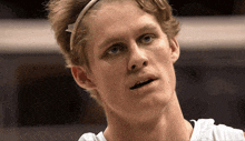 a close up of a man 's face with a headband around his head