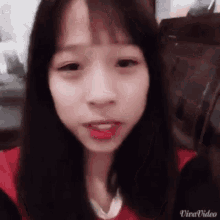 a young girl with long black hair is taking a selfie with her phone .
