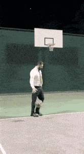 a man in a suit and tie is playing basketball