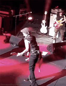 a man playing a guitar on a stage with the words " theroseinthedarkness tumblr " written below him