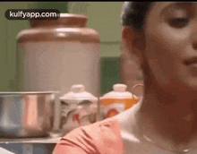 a close up of a woman 's face in a kitchen with a blurred background .