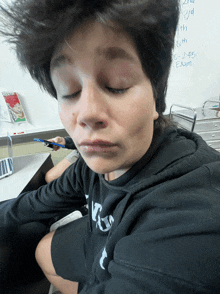 a person with their eyes closed in front of a whiteboard that says exam