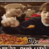 a man is eating a slice of pizza while another man looks on ..