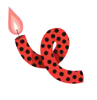 a red and black polka dot candle with a red flame