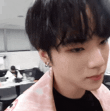a close up of a person 's face with a pink jacket on .