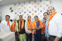 a group of people are posing for a picture in front of a wall that says ' 5 ' on it