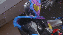 a person in a purple and blue costume with a red bracelet on their wrist