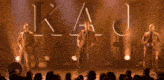 a group of men singing in front of a sign that says kj