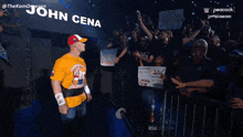 a man in a yellow shirt stands in front of a sign that reads john cena