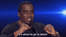 a man speaking into a microphone with the words it 's about to go to down