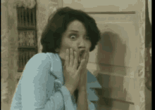 a woman in a blue robe is making a funny face