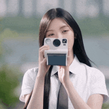a girl in a white shirt and tie is taking a picture