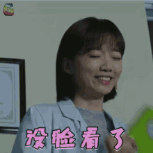 a woman in a lab coat is smiling with her eyes closed and chinese writing on the bottom of her shirt .