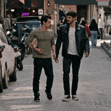 two men walking down a street in front of a coffee sign
