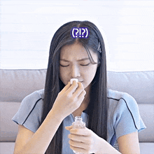 a woman with a question mark on her head holds a bottle of water