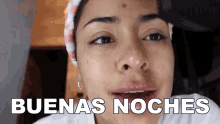 a close up of a woman 's face with the words buenas noches behind her