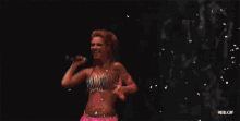 a woman in a pink top and skirt is dancing in the rain .