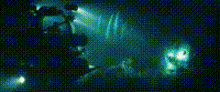 a blurry picture of a person standing in a dark room with a blue background .