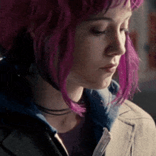 a woman with purple hair is wearing a jacket