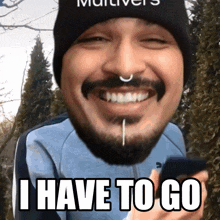a man with a beard is smiling and holding a cell phone with the words " i have to go " on the bottom