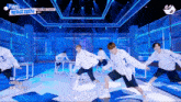 a group of young men are dancing on a stage with a sign that says tws