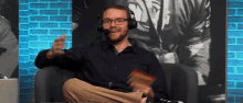 a man wearing headphones and glasses is sitting in a chair