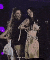 two women are dancing on a stage with the name basss_1922 on the bottom right