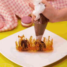 a person is piping chocolate on a dessert with caramel swirls