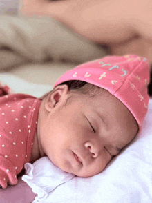 a baby is wearing a pink hat that says cute on it