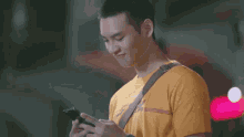 a young man wearing a yellow dhl t-shirt is looking up at the sky .