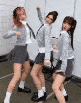 three girls in school uniforms are dancing in front of a sign that says " warning "
