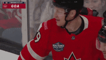 a hockey player wearing a jersey that says nations face off