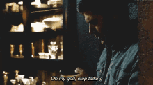 a man is talking on a cell phone and saying oh my god stop talking .