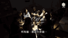 a group of people are sitting in a circle with chinese writing on the bottom right