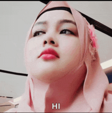 a woman wearing a pink hijab says hi on the bottom right
