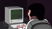 a man is typing on a keyboard in front of a computer that says apple on it