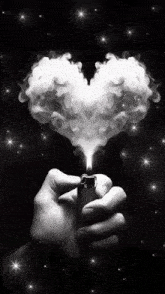 a black and white photo of a person holding a lighter and smoke coming out of it in the shape of a heart