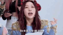 a girl with red hair is wearing a blue sweater with gold pearls on the sleeves
