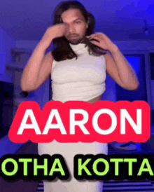 a man in a white tank top is standing in front of a sign that says " aaron otha kotta "