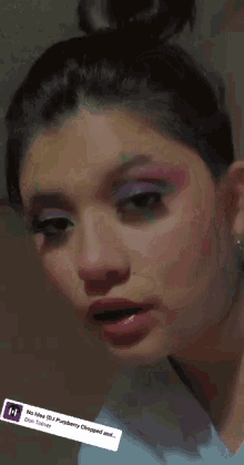 a close up of a woman 's face with a purple eye shadow