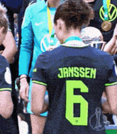 a woman wearing a jersey with the name janssen on the back