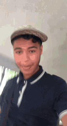 a young man wearing a hat and a polo shirt is smiling