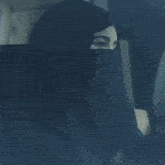 a woman wearing a hijab is looking out of a car window