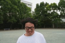 a man wearing glasses makes a funny face in front of trees