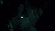 a close up of a woman 's face in a dark room with green light coming out of her eyes .