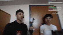 two men are standing next to each other in front of a door with the number 6304/6400 on the bottom