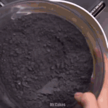 a close up of a pot filled with a yellow liquid and black powder
