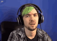 a man with green hair is wearing headphones and the word jsp is visible in the corner