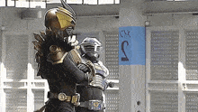 a man in a superhero costume is standing next to another man in a superhero costume in a room .